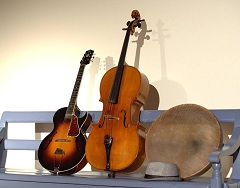 gitarre-cello-handtrommel-auf-gartenbank-klein